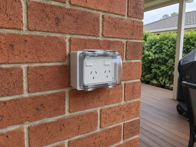 Outdoor double power point on a red brick wall beside a covered deck in Noraville